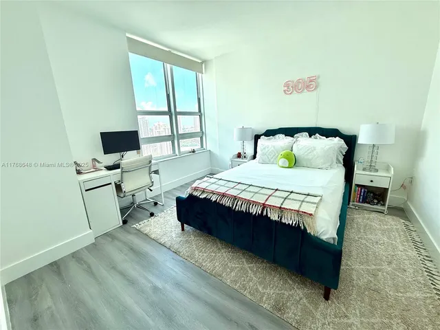 a bedroom with a bed wooden floor and a table