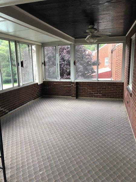 181 Hinkel Road Pittsburgh, PA 15229 - Photo 15 of 18 Large patio/playroom off kitchen with carpet and a wall of windows with a view.