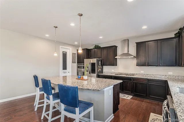 a kitchen with kitchen island granite countertop wooden cabinets a refrigerator and a sink