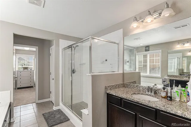 a bathroom with a granite countertop sink and a bathtub