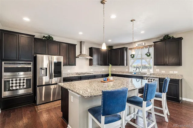 a kitchen with stainless steel appliances granite countertop wooden floor sink and stove