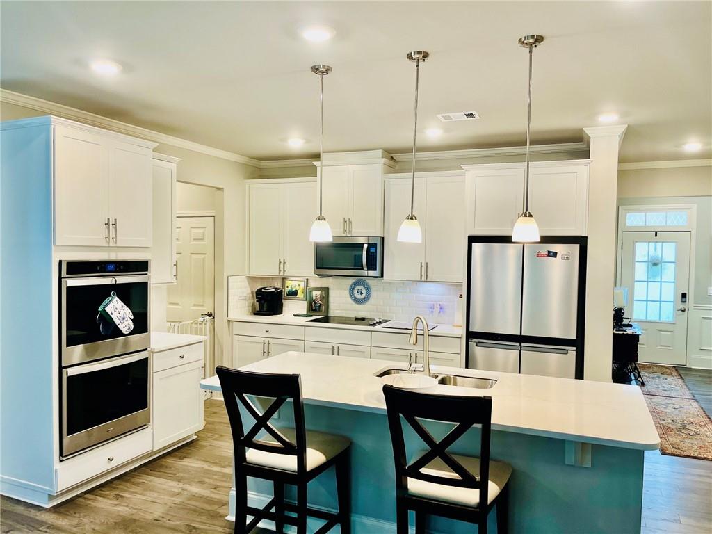 3015 Winding Ridge Waleska, GA 30183 - Photo 9 of 40 a kitchen with stainless steel appliances granite countertop a stove refrigerator and chairs