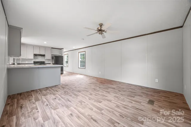 a view of a kitchen with wooden floor and window