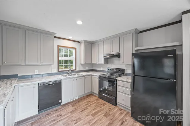a view of a kitchen with wooden floor and window