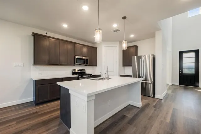 a kitchen with stainless steel appliances a sink stove and refrigerator