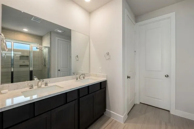 a bathroom with a double vanity sink and mirror
