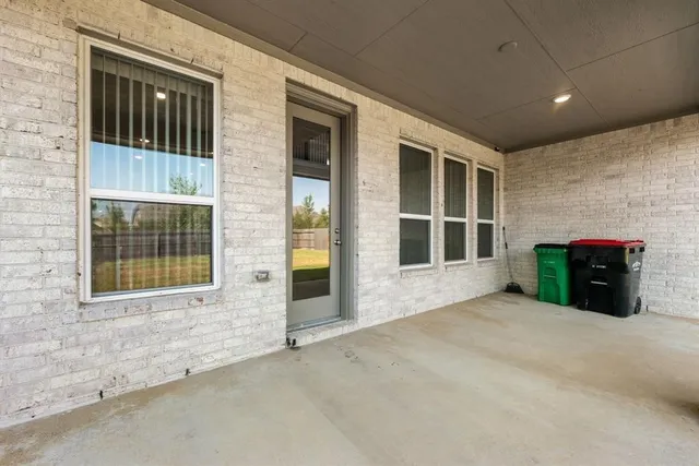 a view of an empty room with a fireplace and a window