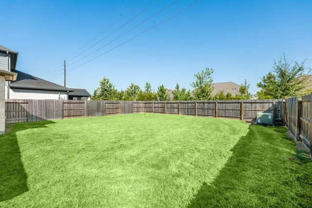 a view of a backyard with a garden and entertaining space