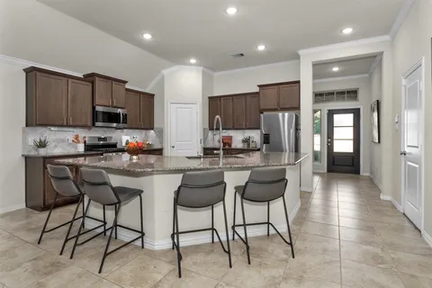 a kitchen with stainless steel appliances granite countertop a stove a sink a refrigerator and a microwave