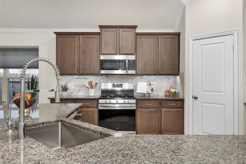 a kitchen with stainless steel appliances granite countertop a sink stove and cabinets