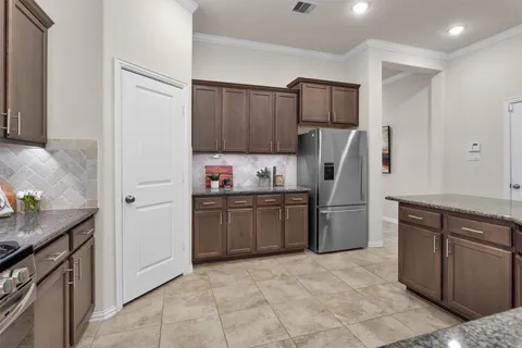 a kitchen with a refrigerator sink and wooden cabinets
