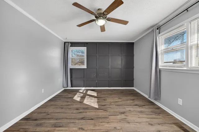 an empty room with fan and windows