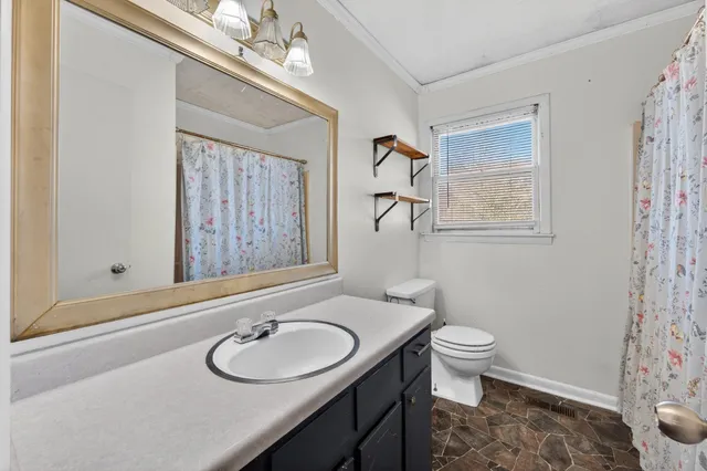 a bathroom with a sink toilet and a mirror