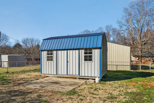 a view of a house with backyard and wooden fence