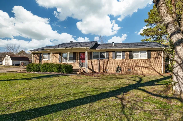 a view of a house with garden and sitting area