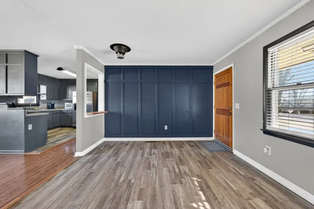 a view of a kitchen with wooden floor and a window