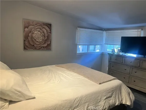 a bedroom with a bed and a flat screen tv