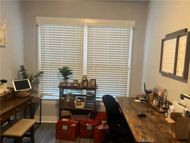 a view of a workspace with furniture and a window