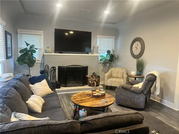 a living room with furniture a fireplace and a flat screen tv