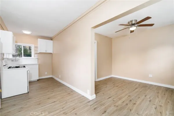 a view of a kitchen with wooden floor and a ceiling fan