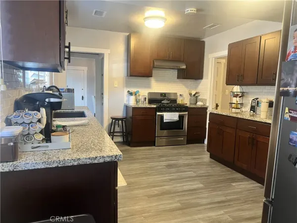 a kitchen with stainless steel appliances granite countertop a sink stove and refrigerator