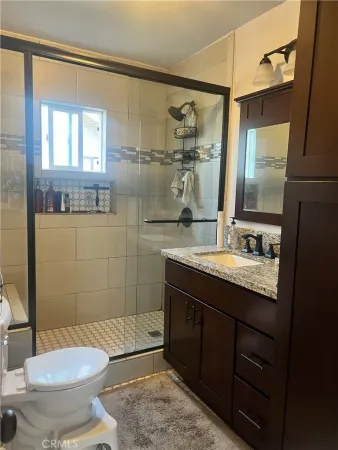 a bathroom with a granite countertop sink toilet and shower
