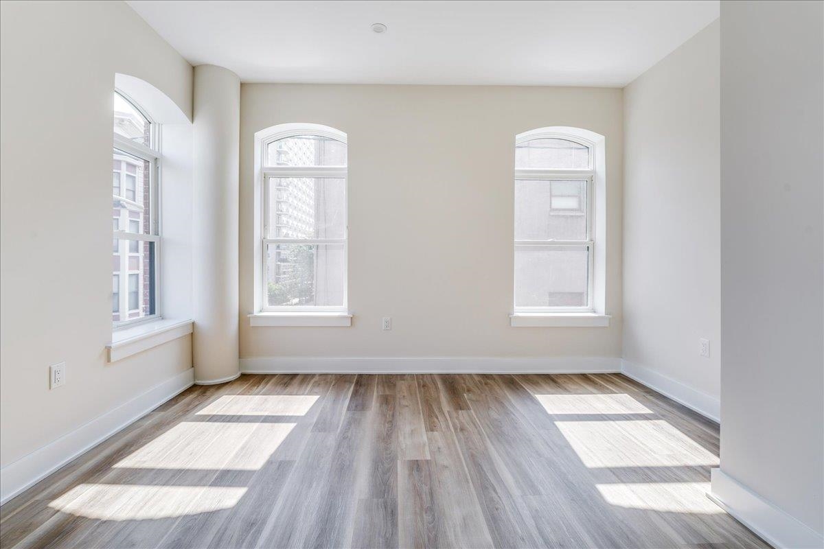 237 Washington Street, Unit 304 Hoboken, NJ 07030 - Photo 16 of 34 an empty room with wooden floor and windows