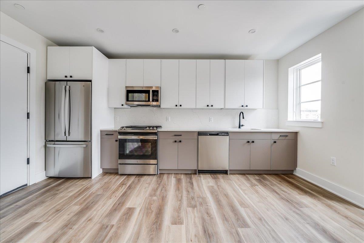 237 Washington Street, Unit 304 Hoboken, NJ 07030 - Photo 2 of 34 a kitchen with a refrigerator and a stove top oven