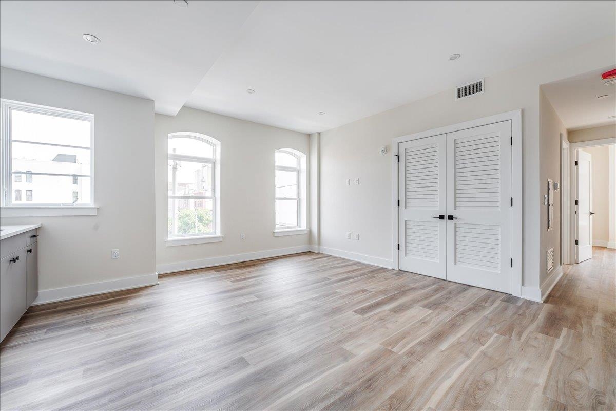 237 Washington Street, Unit 304 Hoboken, NJ 07030 - Photo 5 of 34 an empty room with wooden floor and windows