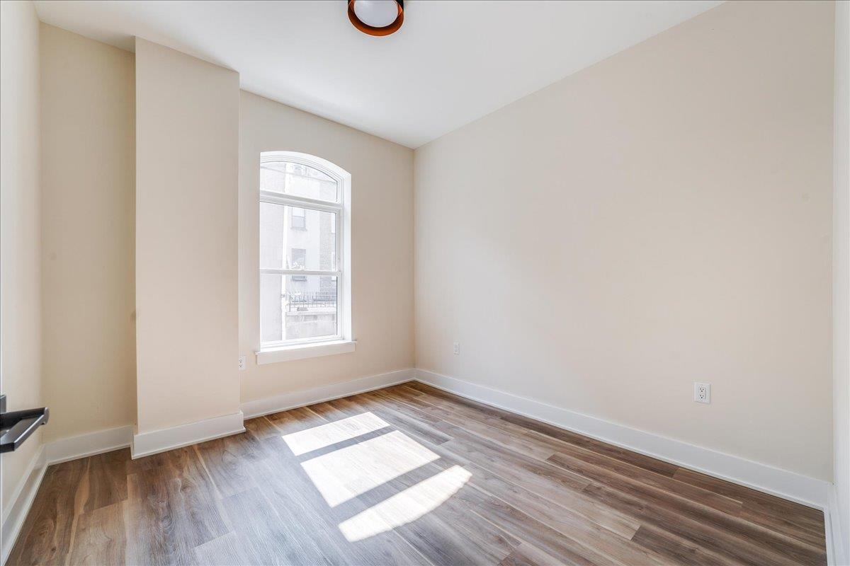 237 Washington Street, Unit 304 Hoboken, NJ 07030 - Photo 9 of 34 an empty room with wooden floor and windows