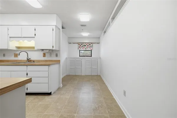 a kitchen with white cabinets and sink