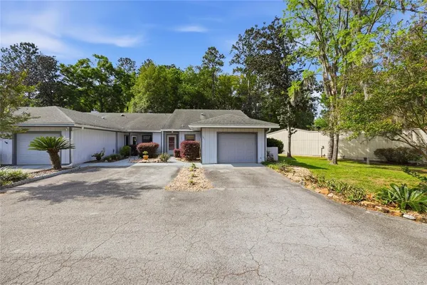 a front view of a house with a garden and trees