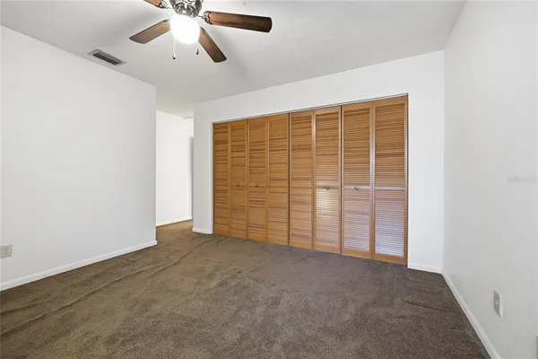 an empty room with a window and a fan