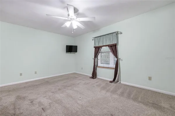 a view of an empty room with a ceiling fan