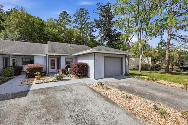 a view of a house with backyard and trees