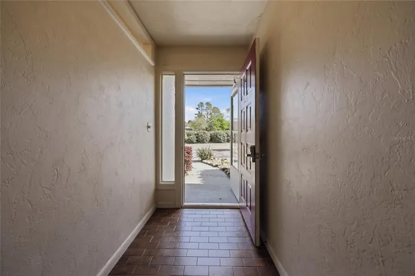 a view of a hallway with wooden floor and a living room