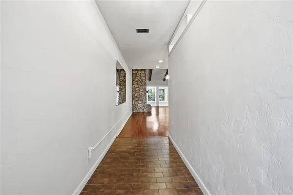 a view of a hallway with wooden floor and staircase