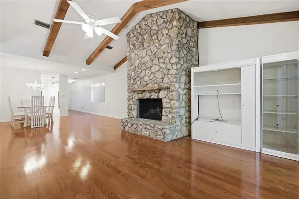 a view of empty room with wooden floor and fireplace