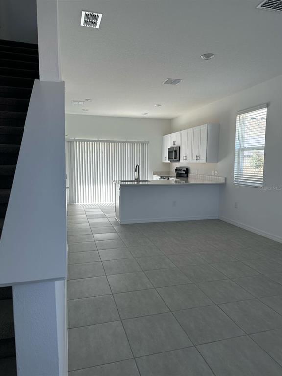 2084 Viewfinder Street Kissimmee, FL 34758 - Photo 3 of 18 a view of a kitchen with kitchen island white cabinetry and window