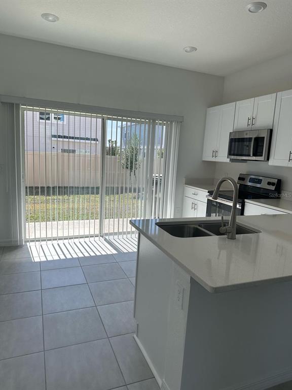 2084 Viewfinder Street Kissimmee, FL 34758 - Photo 4 of 18 a kitchen with stainless steel appliances granite countertop a sink and a stove