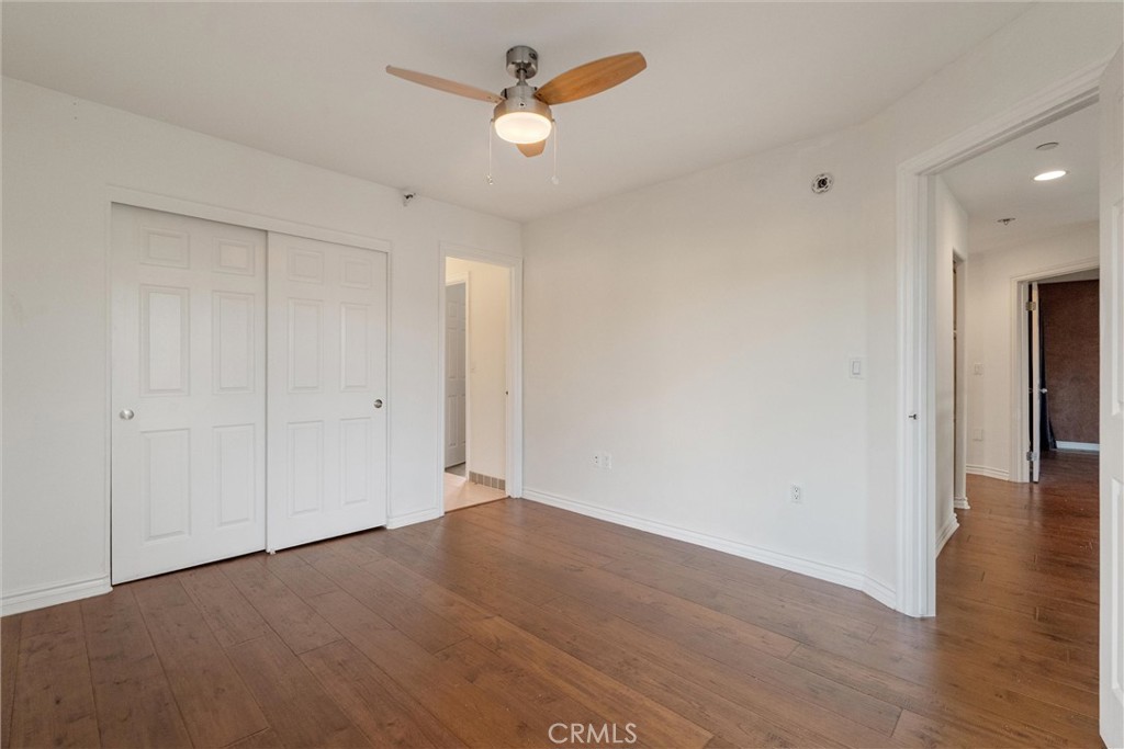 1259 Gonzales Road Simi Valley, CA 93063 - Photo 16 of 39 a view of a room with wooden floor and a ceiling fan