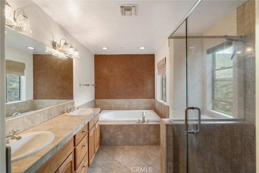 1259 Gonzales Road Simi Valley, CA 93063 - Photo 19 of 39 a bathroom with a granite countertop tub sink and mirror