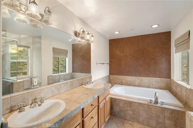 a spacious bathroom with a tub sink and mirror