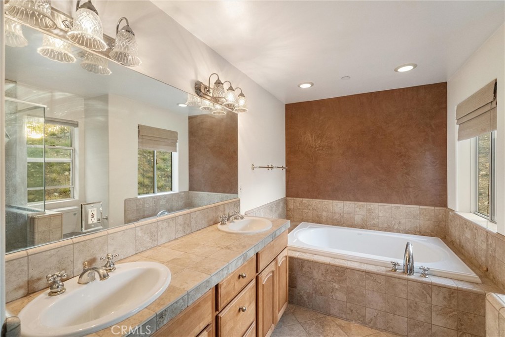1259 Gonzales Road Simi Valley, CA 93063 - Photo 20 of 39 a spacious bathroom with a tub sink and mirror