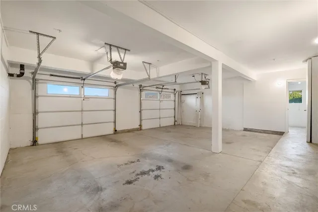 a view of an empty room with cabinet and a hallway