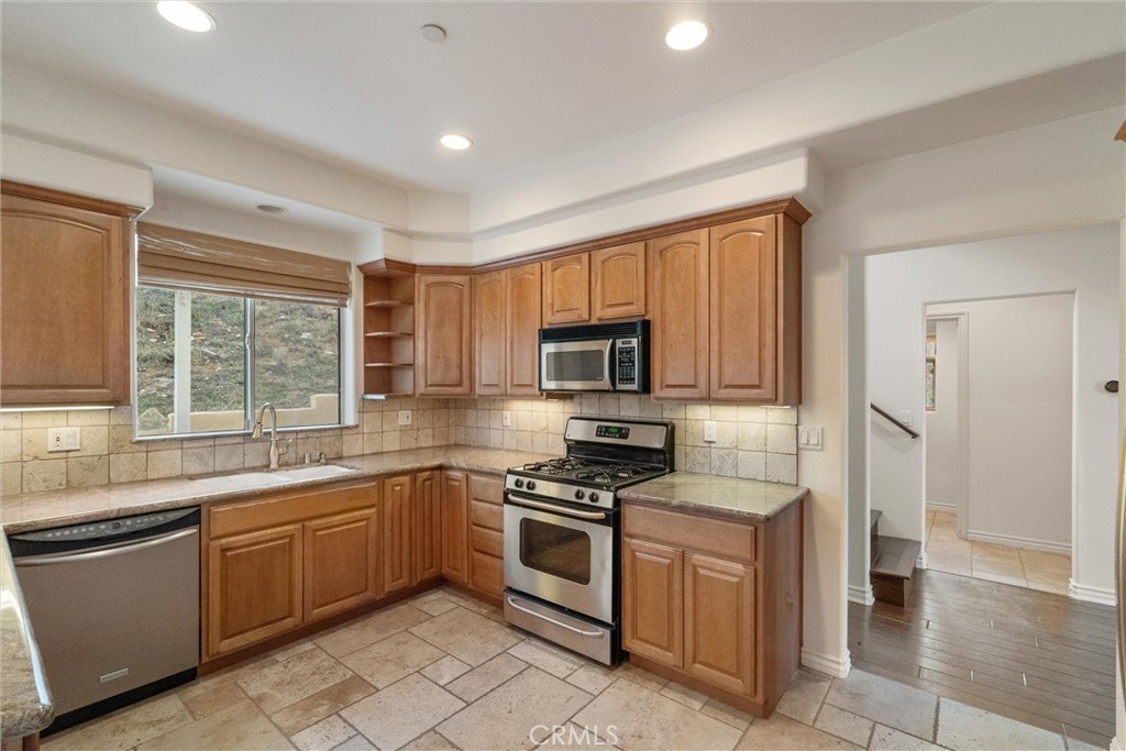 1259 Gonzales Road Simi Valley, CA 93063 - Photo 31 of 39 a kitchen with a sink stove top oven and refrigerator