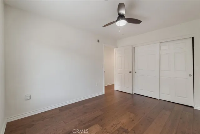 a view of an empty room with wooden floor and window
