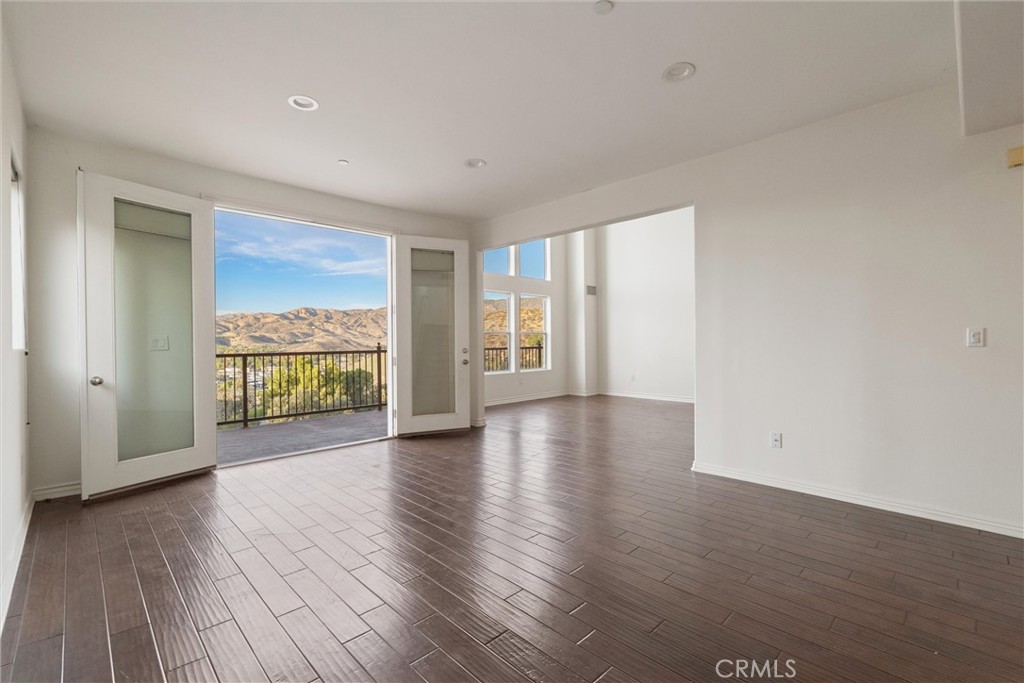 1259 Gonzales Road Simi Valley, CA 93063 - Photo 4 of 39 a view of an empty room with wooden floor and a window