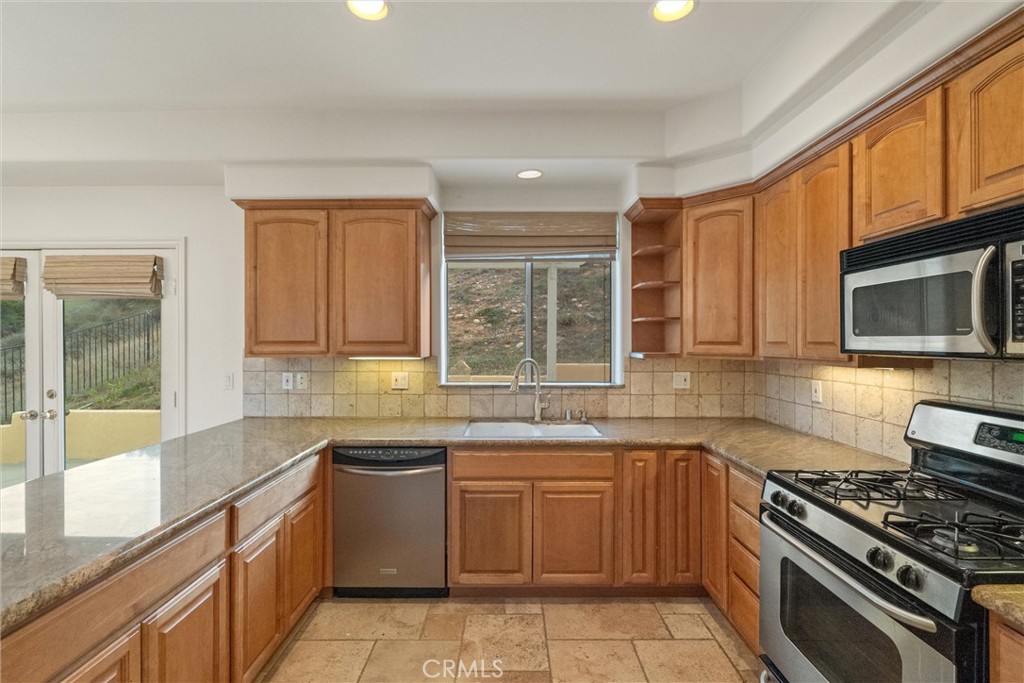 1259 Gonzales Road Simi Valley, CA 93063 - Photo 9 of 39 a kitchen with a sink stove top oven and cabinets