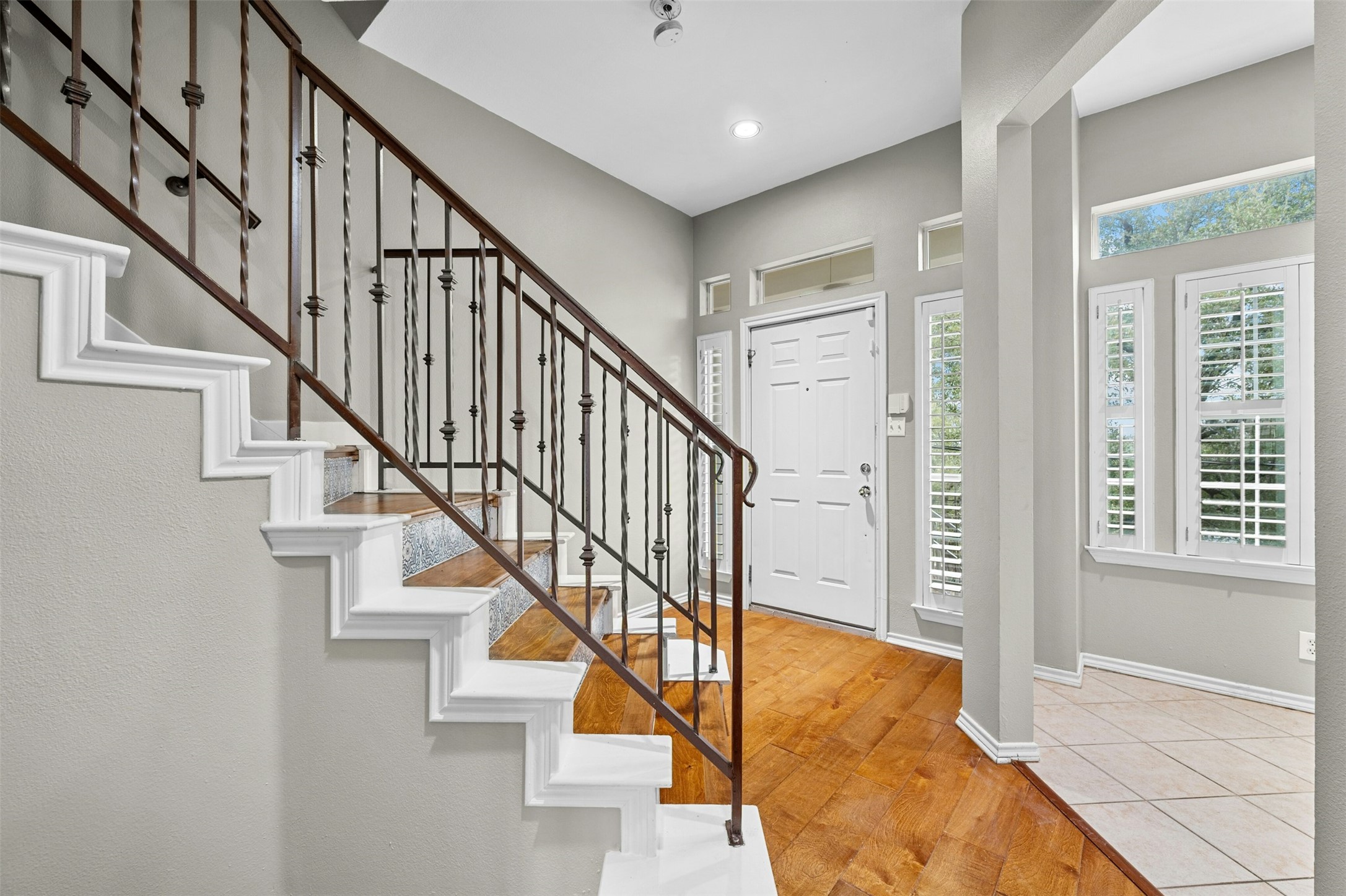 2918 Ranch To Market Road 620, Unit W219 Austin, TX 78734 - Photo 6 of 35 Natural light fills the foyer, complemented by plantation shutters and elegant iron railing along the staircase.